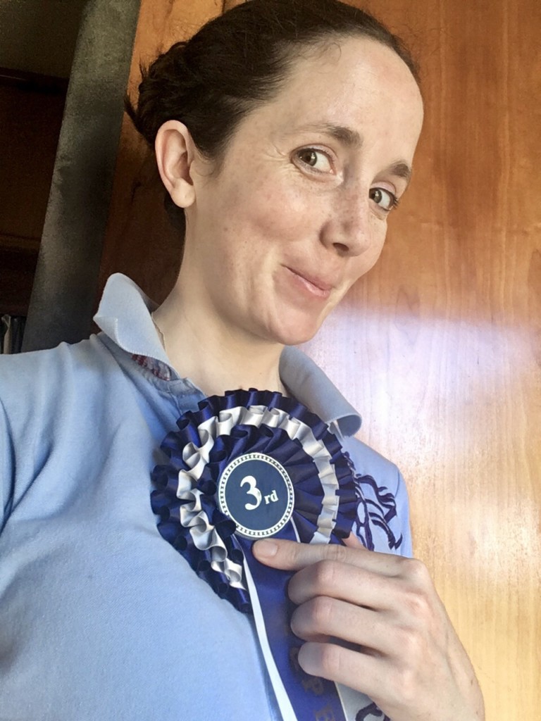 Holding my 3rd rosette from showjumping and smiling